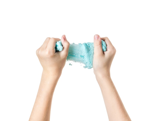 The child's hands stretch a sky-colored slime isolated on a white background. Popular children's game.