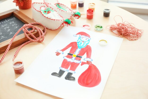 Dipinto per bambini di babbo natale con borsa sul tavolo