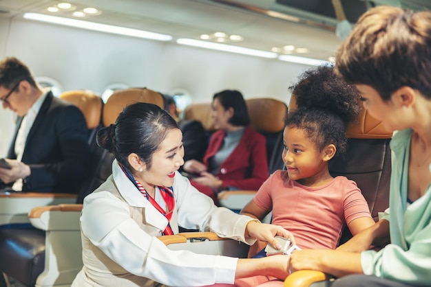 The child's safety belt is being fastened by the air hostess