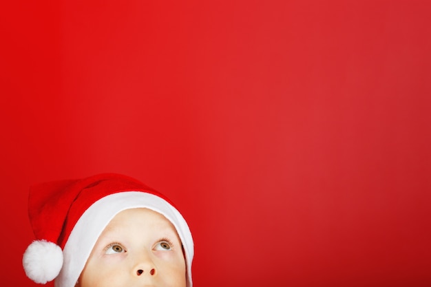 Child in a santa hat looks up from the bottom of the frame