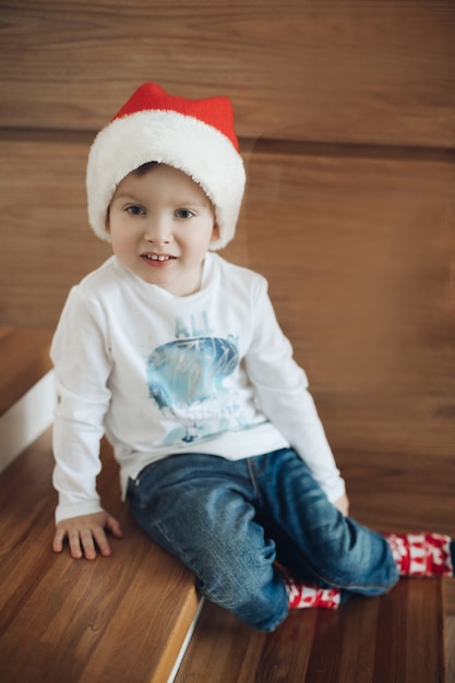 Photo child in santa hat relaxes at home