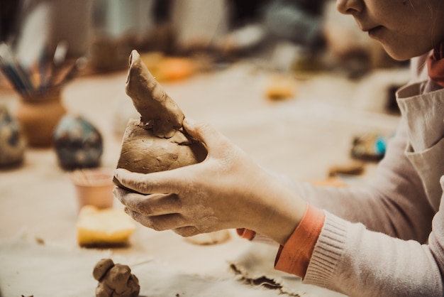 Child sculpts the product from raw clay