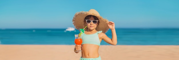 A child at the sea drinks a cocktail. Selective focus.