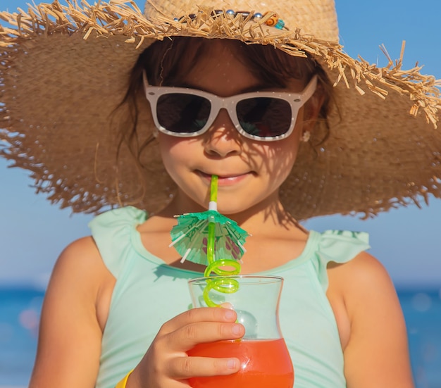 海で子供がカクテルを飲みます。