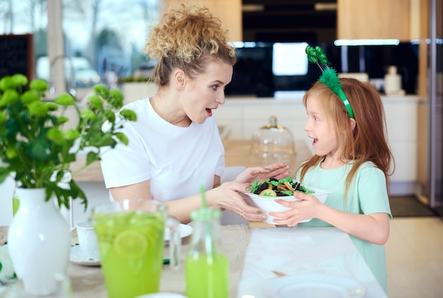 Child sharing cookies with mother