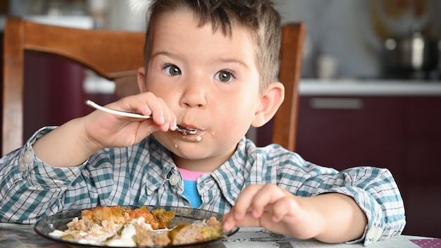 Child in shirt eating close up.