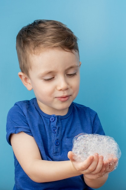 Bambino che mostra le mani con schiuma di sapone, concetto di pulizia e igiene. pulire le mani frequentemente con acqua e sapone aiuterà a prevenire un'epidemia da virus pandemico