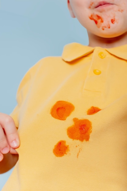 Child showing a stain on his clothes The concept of cleaning stains on clothes