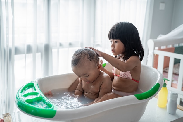Child sibling taking bath together at home