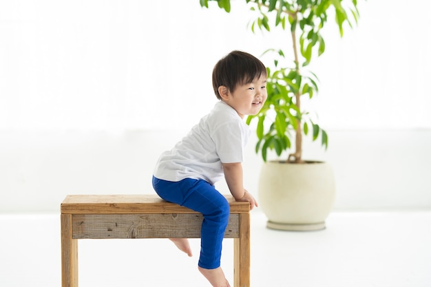 Child sitting on a chair and frolicking with smile