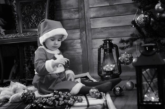 A child sitting in front of a Christmas tree waiting for Santa Claus