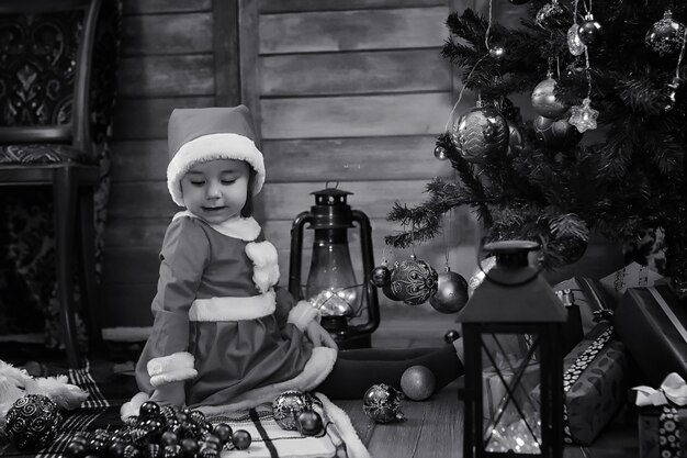 A child sitting in front of a Christmas tree waiting for Santa Claus