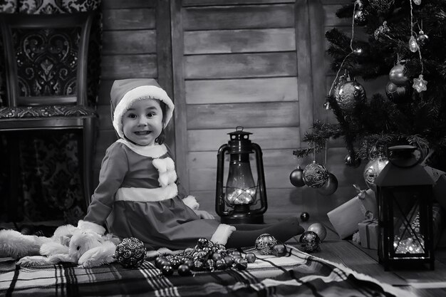 A child sitting in front of a Christmas tree waiting for Santa Claus