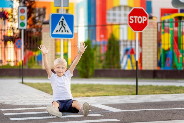 Фото Ребенок сидит на дороге на пешеходном переходе