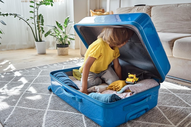 A child sitting in a suitcase have fun and hiding waiting for a trip on vacation