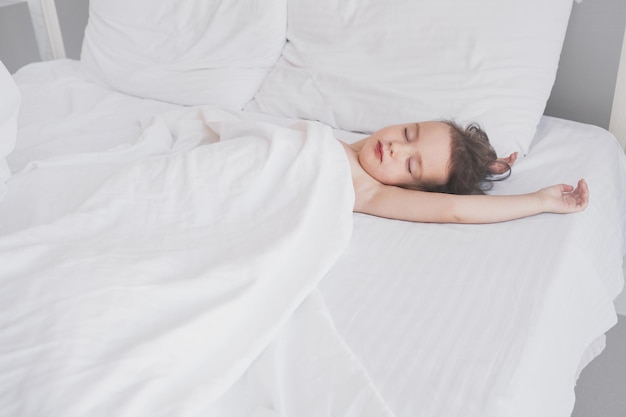 子供はベッドで甘く眠る親のベッドで子供を眠る子供はぐっすり眠る...