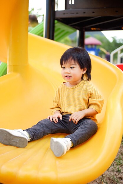 A child slides down a slide at a playground.