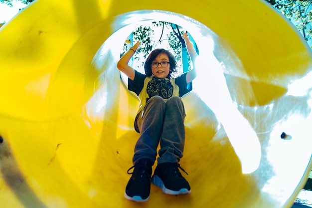 Foto bambino che scivola nel parco giochi