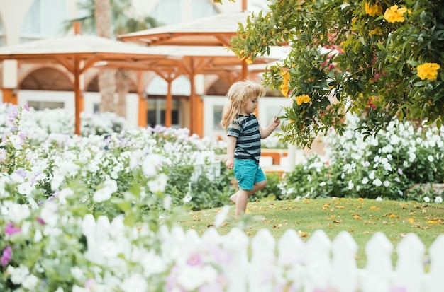 Child or small boy outdoor near white wooden fence