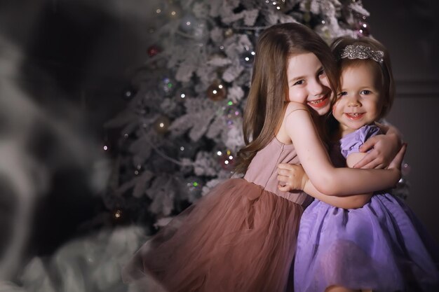 Child in smart clothes in front of the Christmas tree New Years Eve Waiting for the new year