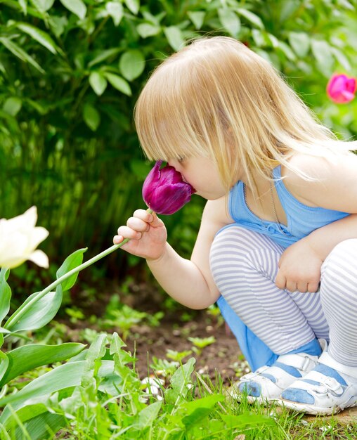 花の匂いを嗅ぐ子供
