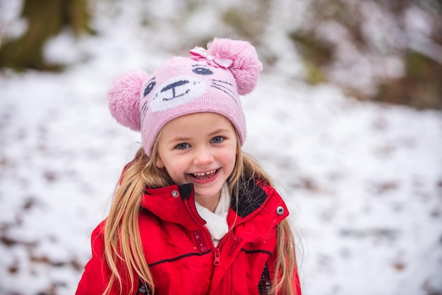 눈 속의 아이 겨울 눈 덮인 공원에서 즐거운 시간을 보내는 어린 소녀