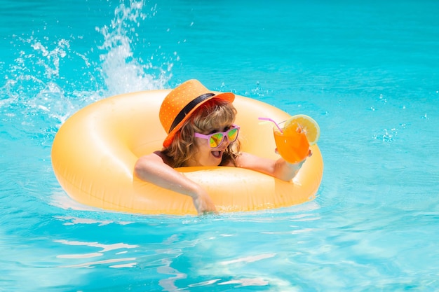 スイミングプールで水しぶきの子供アクティブな健康的なライフスタイル夏の休暇でウォータースポーツ活動を泳ぐ