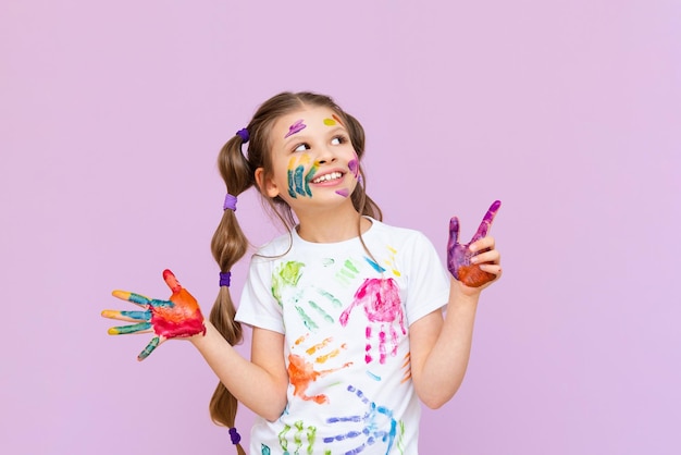 A child stained in multicolored paints will have to be creative\
the concept of children\'s creativity on a pink isolated\
background