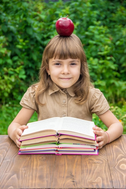 赤いリンゴの選択的な焦点を持つ子供の学生