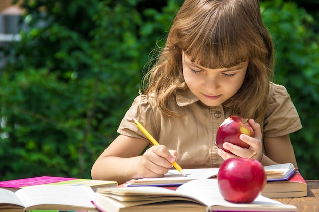 赤いリンゴの選択的な焦点を持つ子供の学生