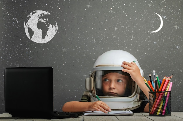 The child studies remotely at school, wearing an astronaut's helmet. back to school.  effects glitch