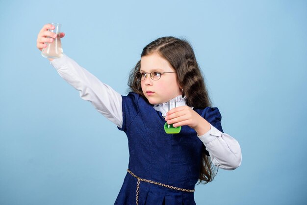 子供の研究生物学のレッスン。未来を発見してください。テストフラスコを持つ小さな女の子の科学者。教育と知識。研究室での科学研究。小さな天才少女。学校に戻る。化学で、私はできます。