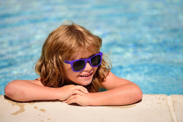Child in summer pool. Summer kids weekend. Happy boy in sunglasses. Kid in swimming pool. Summertime vacation.