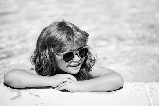 Child in summer pool Summer kids weekend Happy boy in sunglasses Kid in swimming pool Summertime vacation