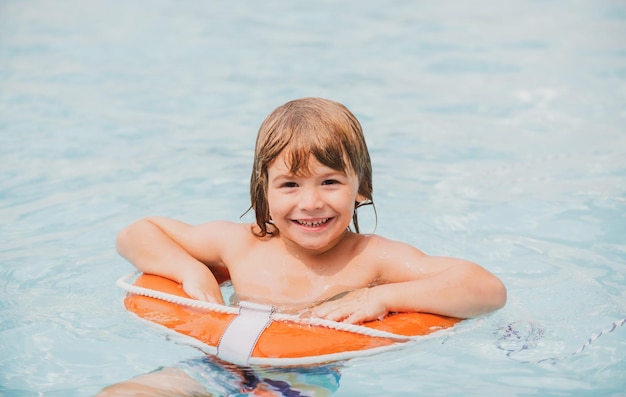 Child in summer pool Summer kids weekend Happy boy in swiming pool on inflatable circle at aquapark Summertime vacation