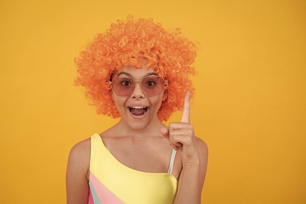 Child in sunglasses and swimsuit inspired with idea on yellow background inspiration