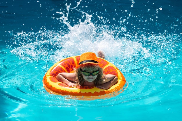 Child swimming in pool play with floating ring smiling cute kid in sunglasses swim with inflatable r