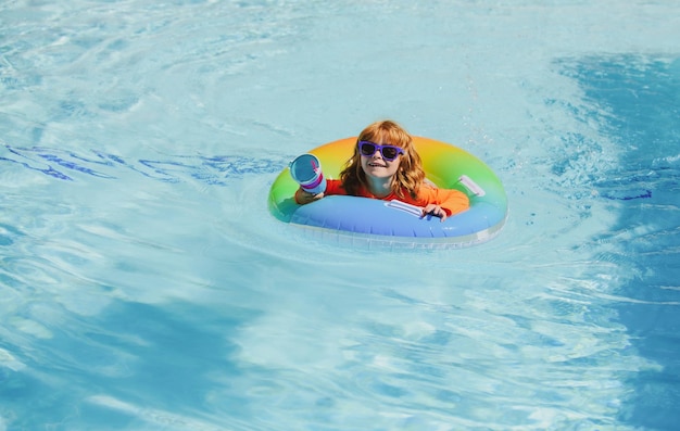 Bambino in piscina che gioca in vacanza nello spazio della copia dell'acqua e viaggia con i bambini i bambini giocano ou
