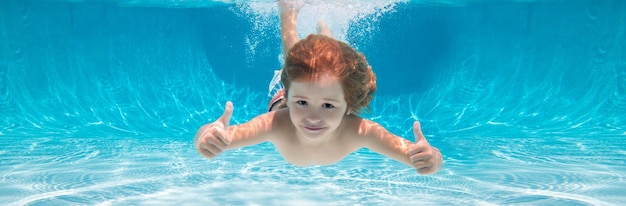 Child swimming underwater with thumbs up Underwater kid swim under water Child boy swimming and diving underwater in pool Banner for header copy space Poster for web design