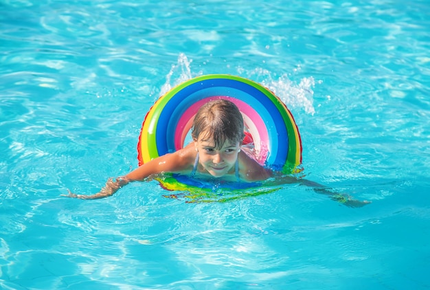 The child swims and dives in the pool. Selective focus.