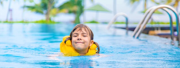 The child swims in the pool in the summer