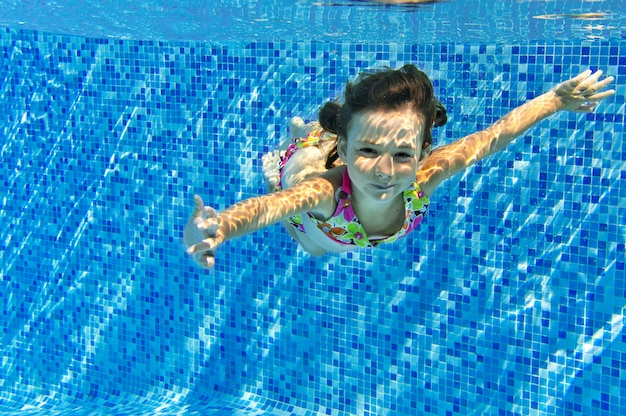 Child swims in pool underwater