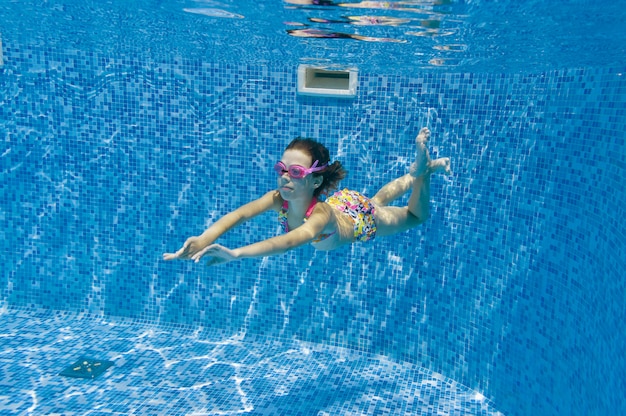 Child swims in pool underwater