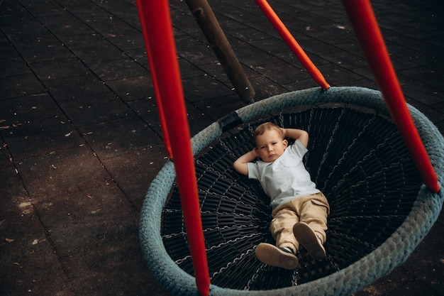 Bambino oscilla nel parco giochi su una giostra rotonda