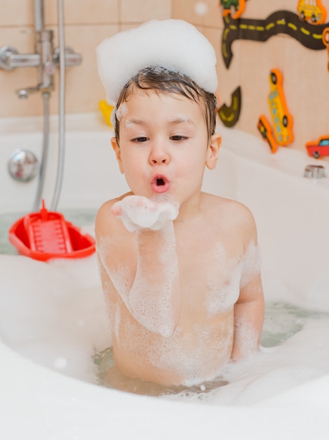 A child taking a bath with foam