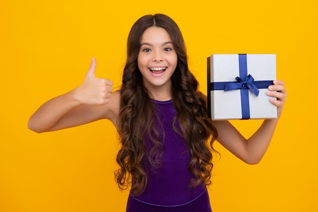 Child teen girl 1214 years old with gift on isolated background birthday holiday concept teenager hold present box happy girl face positive and smiling emotions