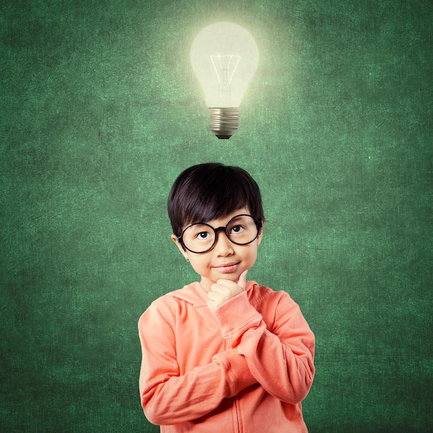 Child in thinking poses while looking at lamp