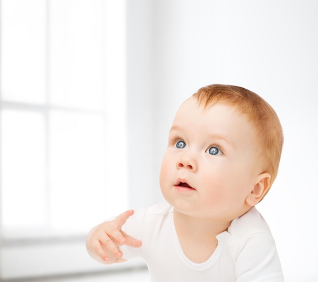 child and toddler concept - curious baby looking up