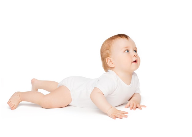 child and toddler concept - smiling baby lying on floor and looking up