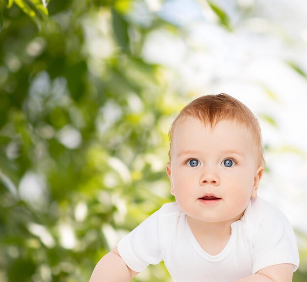 child and toddler concept - smiling baby lying on floor and looking up